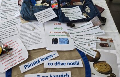 Připravený stůl s předměty a texty na smyslovou aktivizaci na téma: pánská kapsa