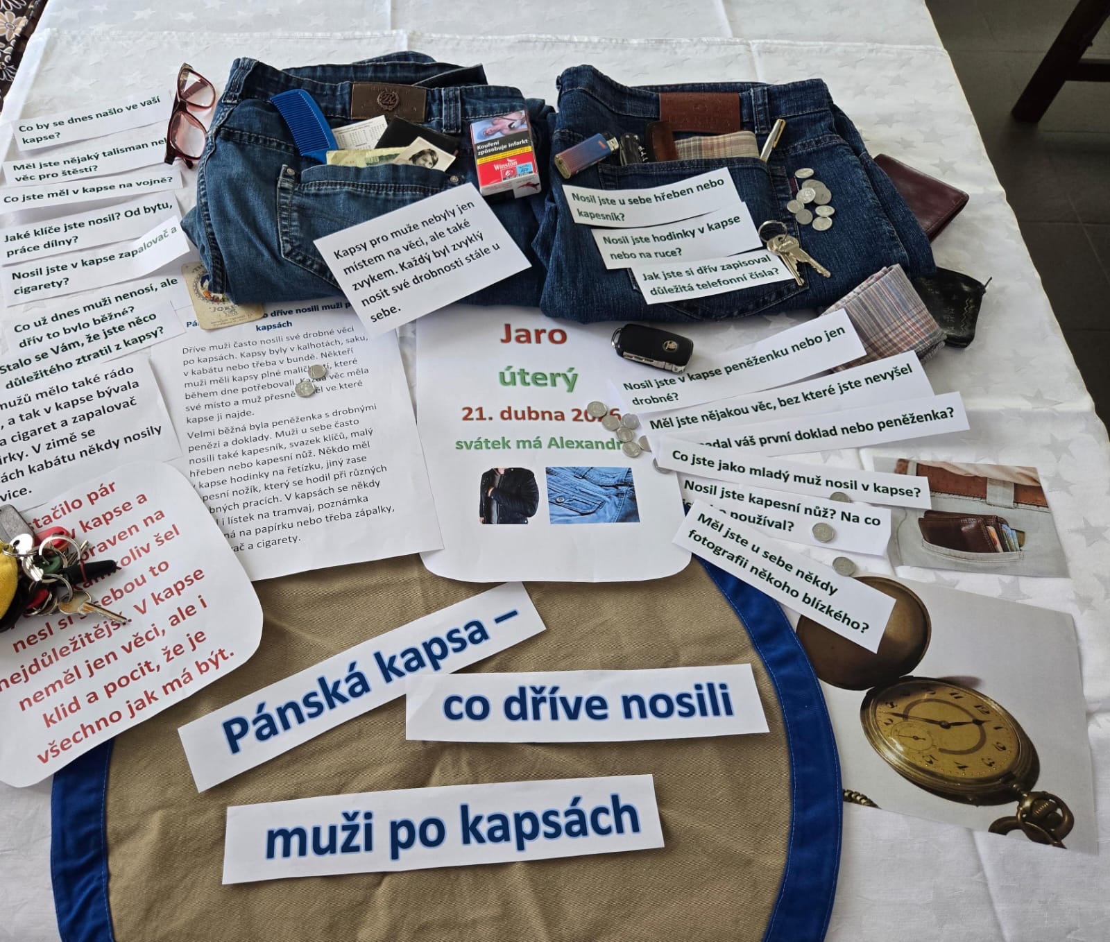 Připravený stůl s předměty a texty na smyslovou aktivizaci na téma: pánská kapsa