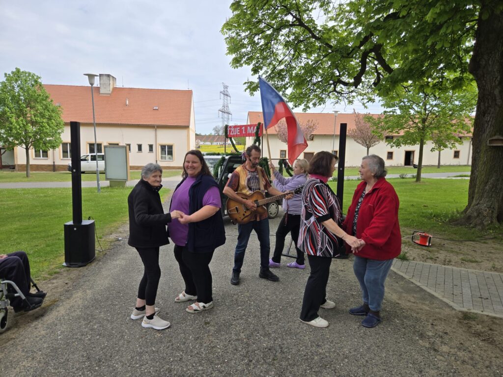 Taneční veselí v pozadí s hudebníkem a alegorickým vozíkem