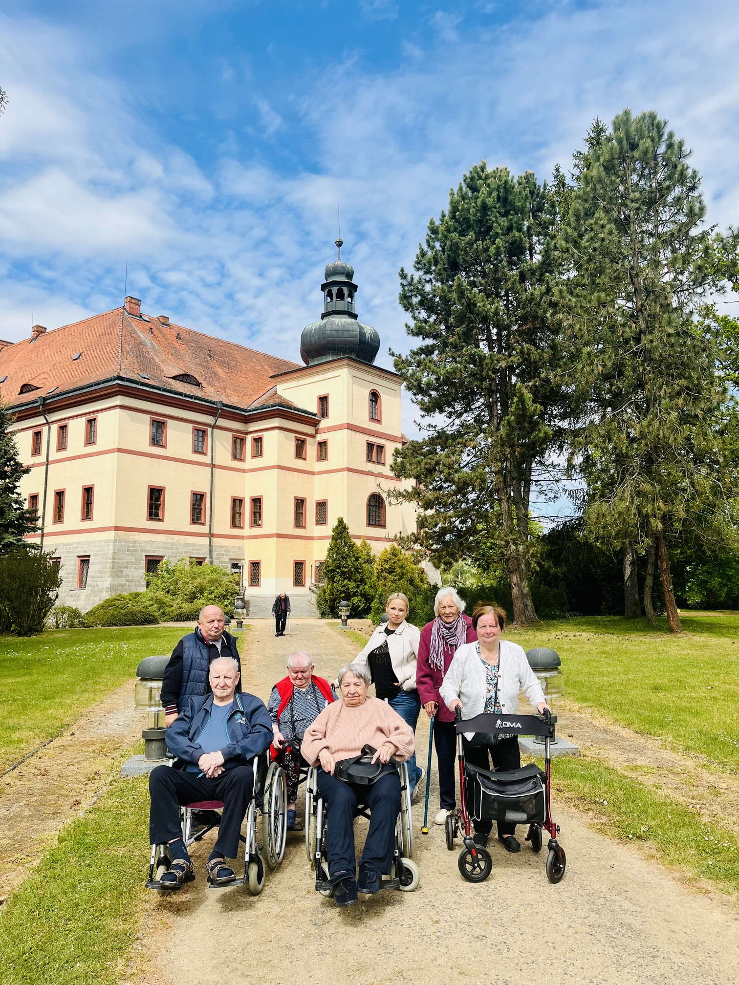 Klienti pózují v parku zámku Lnáře, který je vidět na pozadí