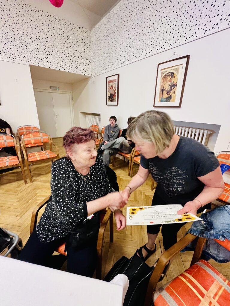 Klientka přebírá diplom za vítězství v soutěži