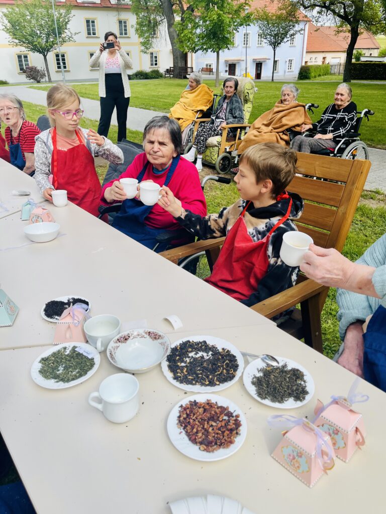 Děti a klienti si připíjejí čajem