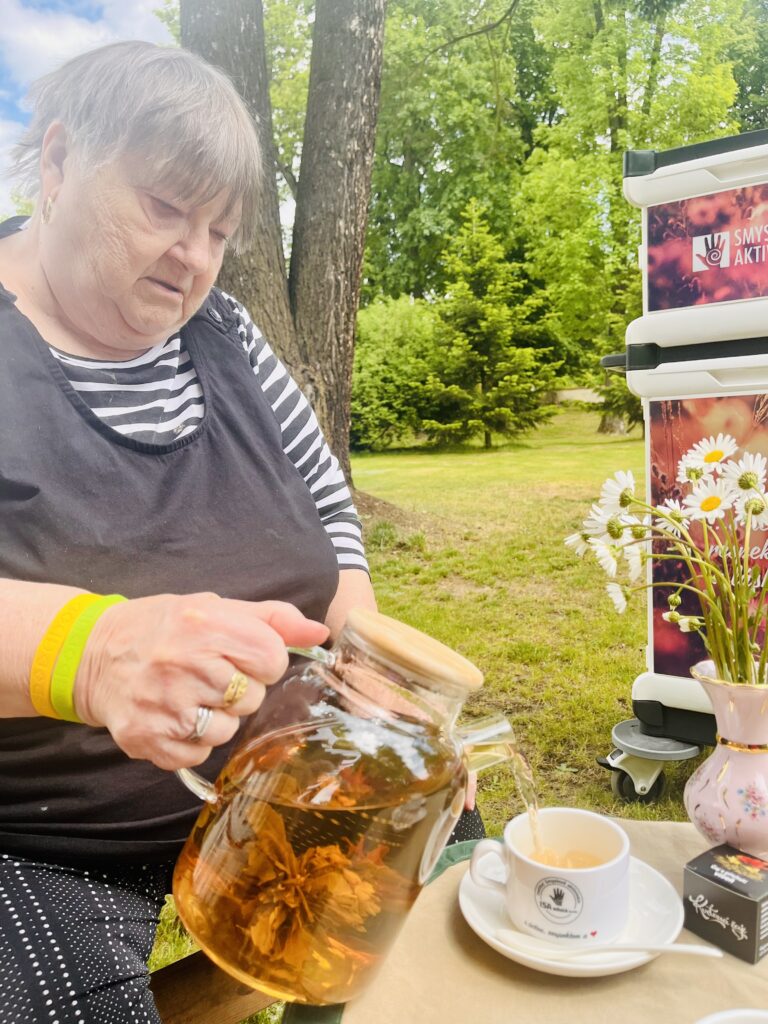 Klientka nalévá z konvičky čaj