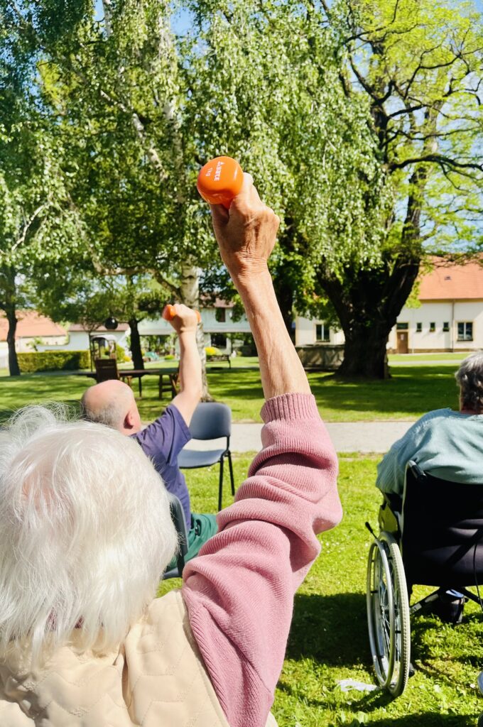 Klienti cvičí s činkami.