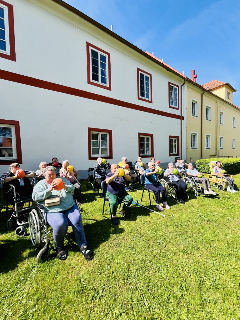 Skupina klientů cvičí s overbally.