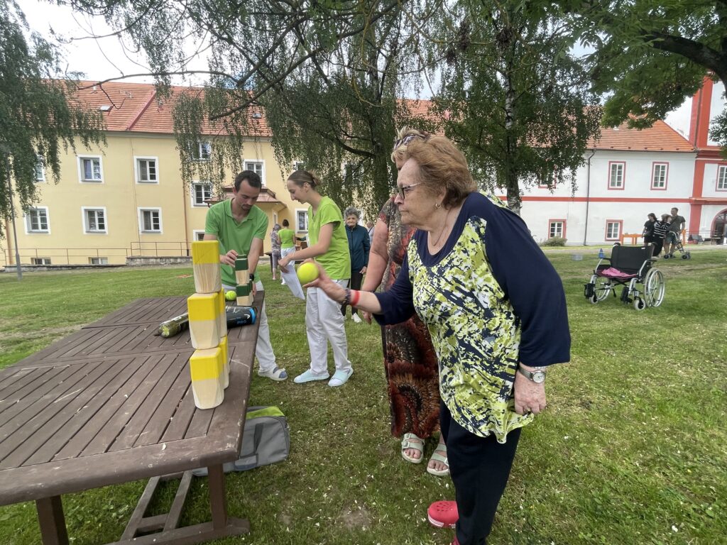 Klientka hází míčkem na dřěné kvádry