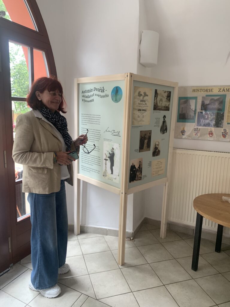 PhDr. Eva Dittertová, emeritní ředitelka Náprstkova muzea, stojí u panelu výstavy Rusalka