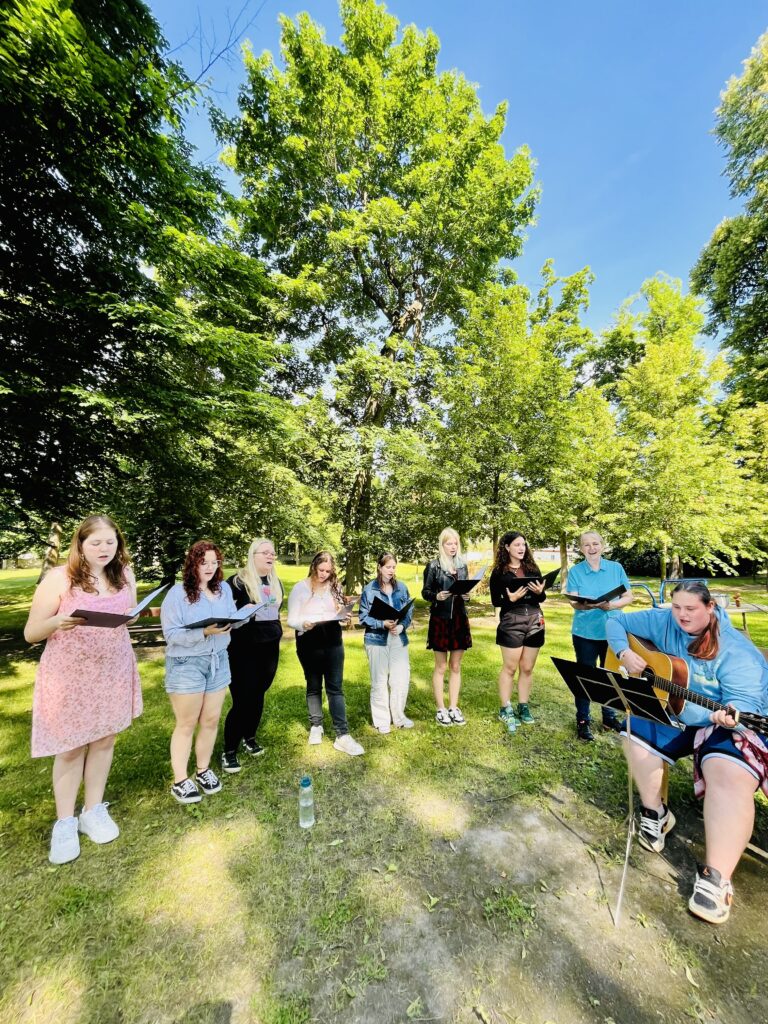 Studentský sbor Výkvět zpívá venku klientům