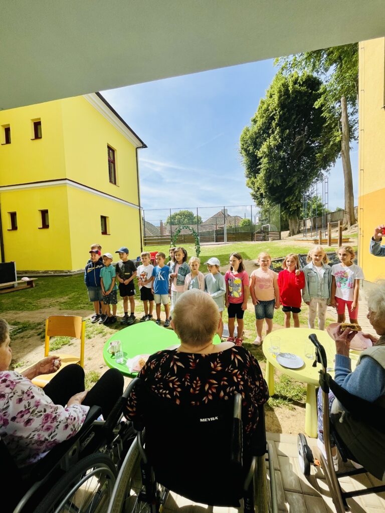 Klienti našeho domova sledují vystoupení dětí