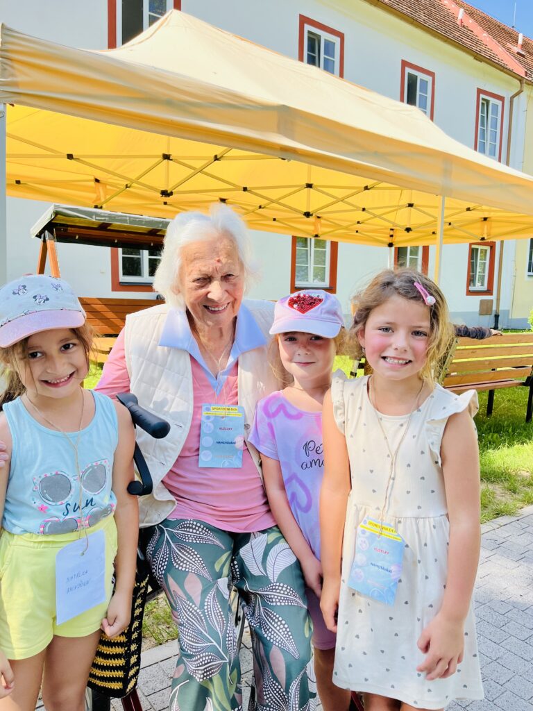 Klientka pózuje na společnou fotografii s dětmi z Mateřské školy