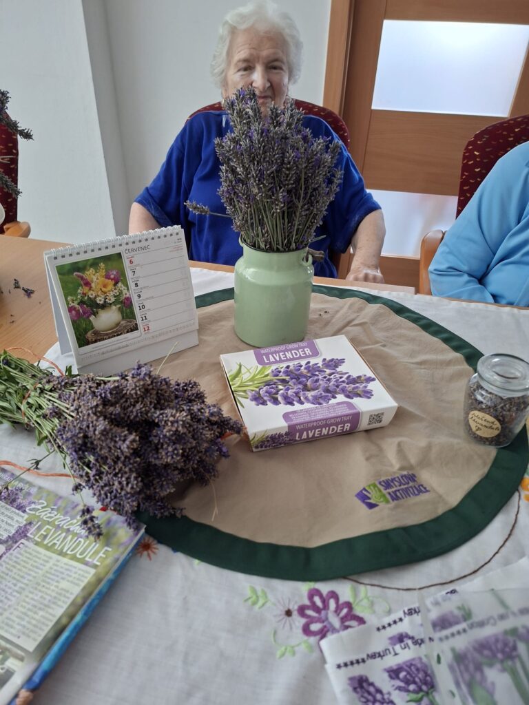 klientka sedící u stolu s pomůckami na smyslovou aktivizaci