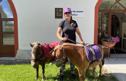 Aneta Řezáčová a její miniponíci před budovou domova v Drhovli