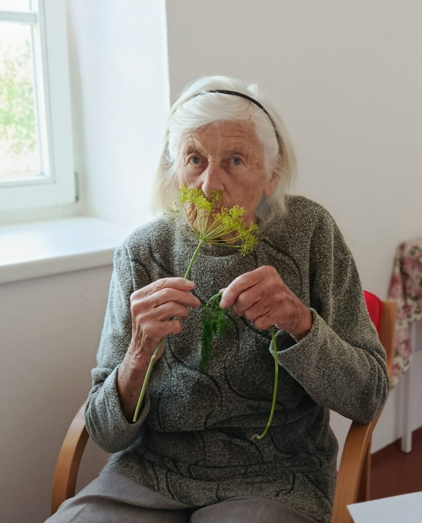 Klientka drží v rukou kopr a vnímá jeho vůni