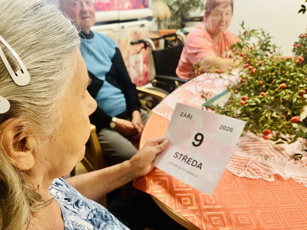 Klientka drží list s datem a ročním obdobím