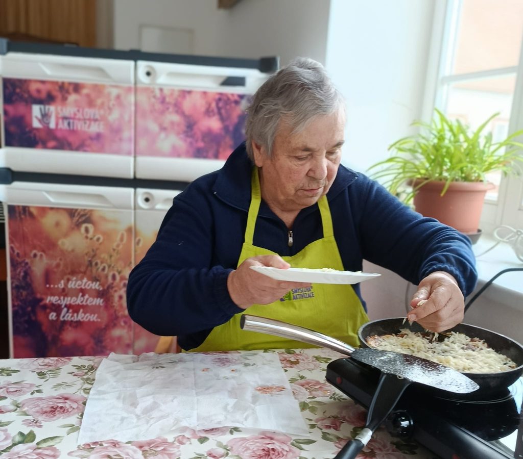 Klientka sype nastrouhaný sýr na omeleru