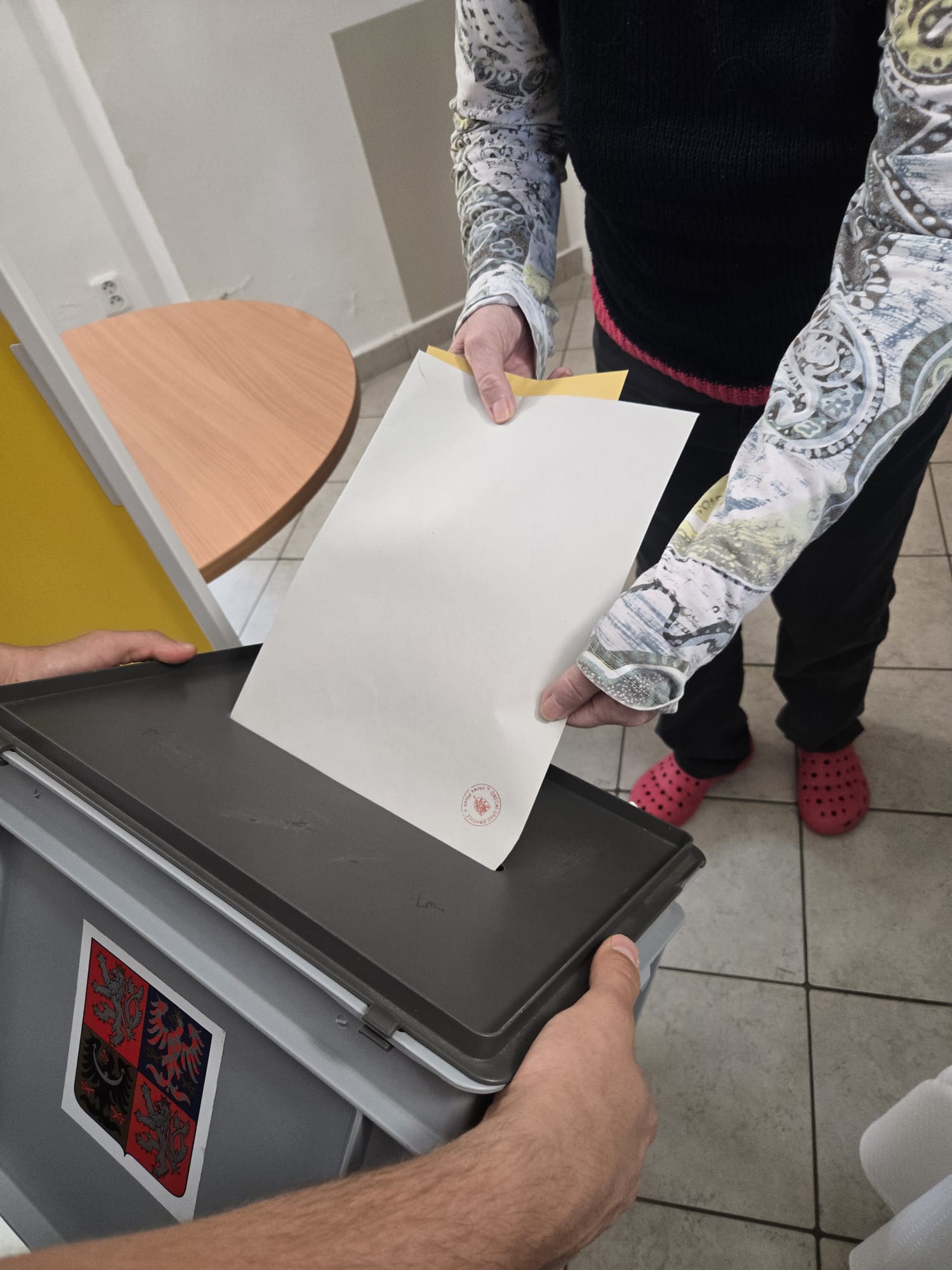 Volič vhazuje své hlasy do přenosné urny
