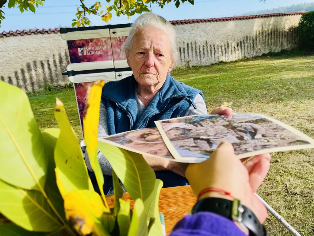 Klientka si vybírá fotografii ke komunikaci ke smyslové aktivizaci na téma sběr ořechů