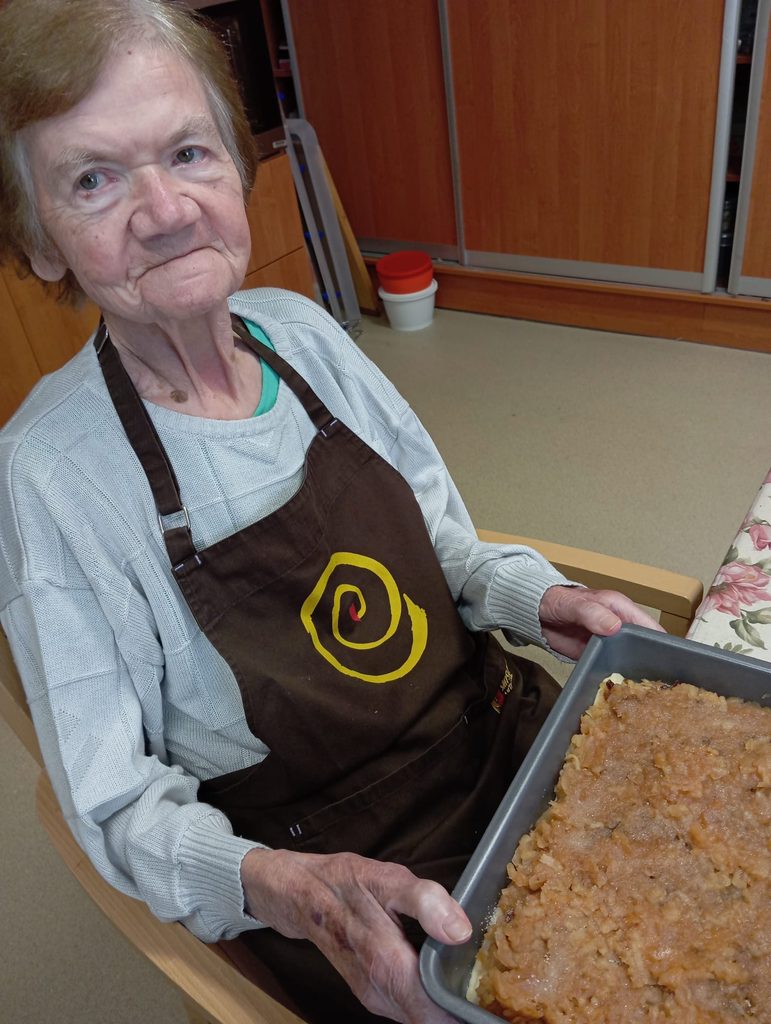 Klientka drží plech s připraveným koláčem před upečením